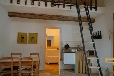 a kitchen and dining room with a ladder and a table at Bakkershuisje Kraneveldhoeve in Haacht