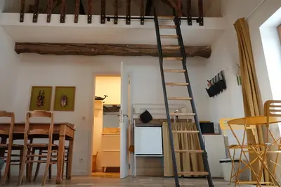 a room with a ladder and a table and chairs at Bakkershuisje Kraneveldhoeve in Haacht