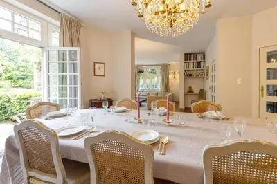 a dining room with a table with chairs and a chandelier at The Castle in Brussels