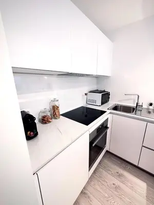 a white kitchen with white cabinets and a sink at Magnificent apartment in Sablon in Brussels