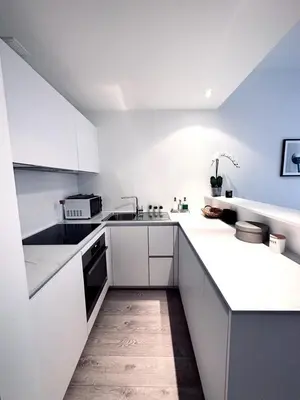 a white kitchen with white cabinets and appliances at Magnificent apartment in Sablon in Brussels