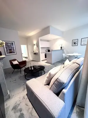 a living room with a large couch and a living room with a kitchen at Magnificent apartment in Sablon in Brussels