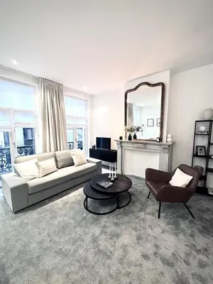 a living room with a couch and a chair and a mirror at Magnificent apartment in Sablon in Brussels