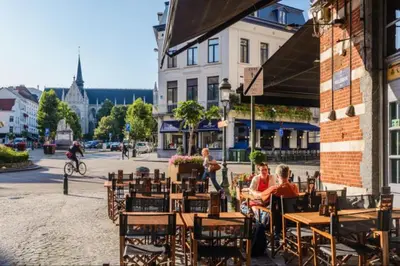 a group of people sitting at an outdoor cafe at Magnificent apartment in Sablon in Brussels