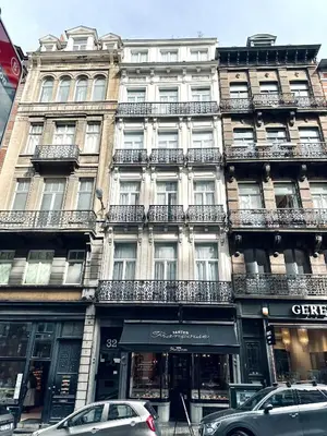 a large building with cars parked in front of it at Magnificent apartment in Sablon in Brussels