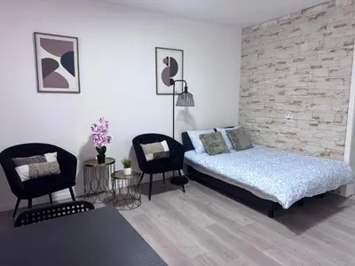 a bedroom with a bed and two chairs at Breughel Apartments in Antwerp