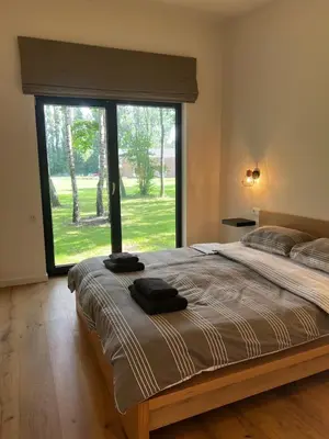 a bedroom with a large bed with a large window at Holiday House Nature in Lier