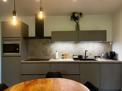a kitchen with a wooden table and a counter top at Holiday House Nature in Lier