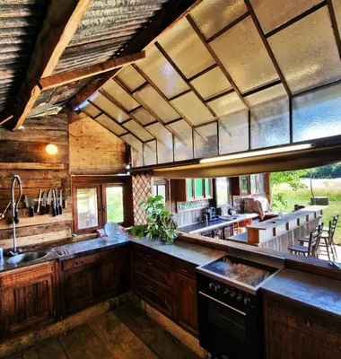 a large kitchen with wooden cabinets and a large counter top at Strackxhoeve Veldtent 'Veldslaap' in Laakdal