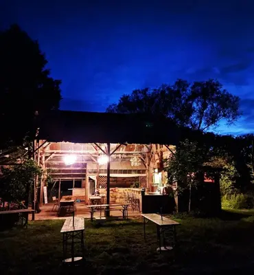 a group of picnic tables in a yard at night at Strackxhoeve Veldtent 'Veldslaap' in Laakdal