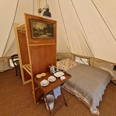a room with a table and a bed in a tent at Strackxhoeve Veldtent 'Veldslaap' in Laakdal