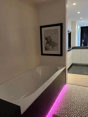 a bath tub with a pink light in a bathroom at Entresol28 in Brussels