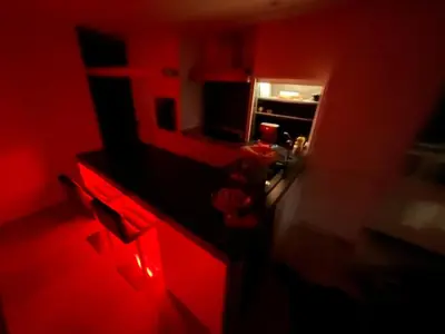 a kitchen with red cabinets and a kitchen with a stove at Entresol28 in Brussels