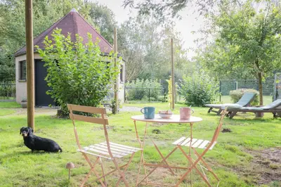 a table and two chairs and a dog in a yard at Octagoon in Tessenderlo