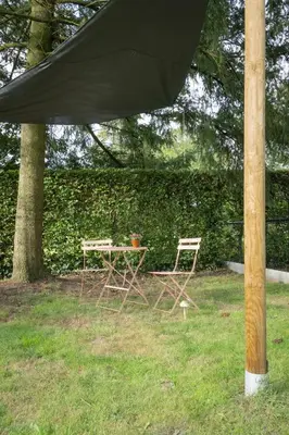 a table and two chairs under a black umbrella at Octagoon in Tessenderlo