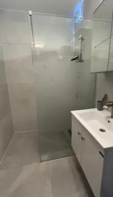 a white bathroom with a shower and a sink at MiMi in Brussels