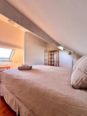 a bedroom with a large bed in a attic at Cosy haven in Aalst with terrace a green haven in Aalst