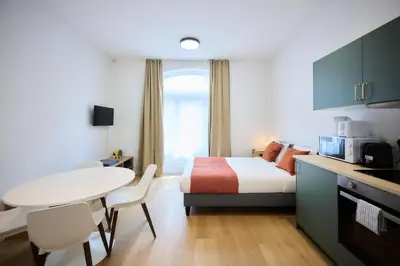a bedroom with a bed and a table and a kitchen at Apartment Duden 1 in Brussels