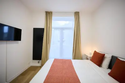 a bedroom with a bed and a large window at Apartment Forest Center 2 in Brussels