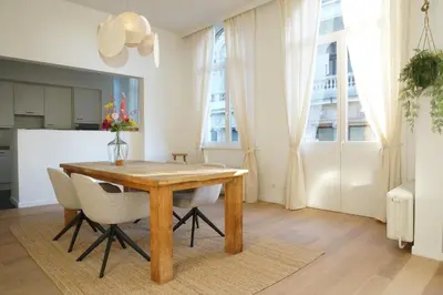 a dining room with a wooden table and chairs at Charming, spacious & luxurious - 2-bedroom apartment at wonderful location in Antwerp