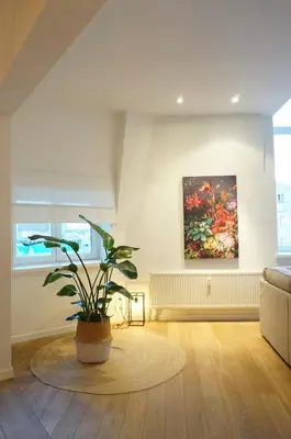 a living room with a potted plant and a painting at Charming, spacious & luxurious - 2-bedroom apartment at wonderful location in Antwerp