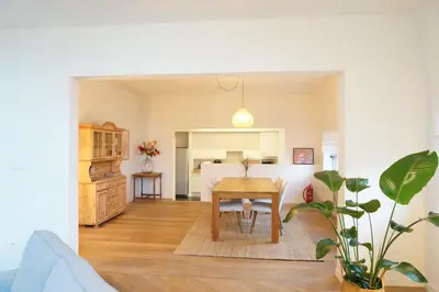 a living room with a table and a kitchen at Charming, spacious & luxurious - 2-bedroom apartment at wonderful location in Antwerp