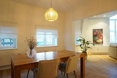 a dining room with a wooden table and chairs at Charming, spacious & luxurious - 2-bedroom apartment at wonderful location in Antwerp