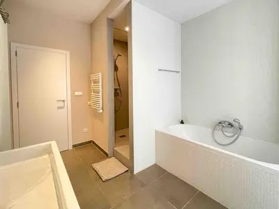 a white bathroom with a tub and a shower at Charming, spacious & luxurious - 2-bedroom apartment at wonderful location in Antwerp