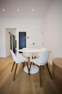 a dining room with a white table and two white chairs at Apartment Wiels 3 in Brussels