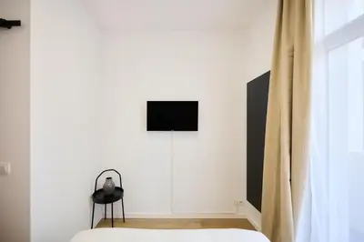 a bedroom with a bed and a television on a wall at Apartment Combaz 4 in Mellet