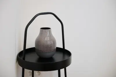a vase sitting on a black stand on a wall at Apartment Combaz 4 in Mellet