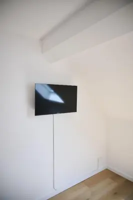 an installation view of a white wall with a spotlight on it at Apartment Berthelot 5 in Brussels