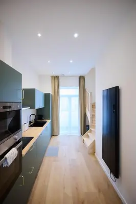 a kitchen with blue cabinets and a black refrigerator at Apartment La Barrière 6 in Brussels