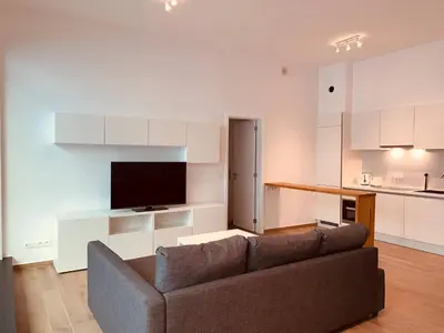 a living room with a couch and a kitchen at The Diplomatic Apartment in Brussels