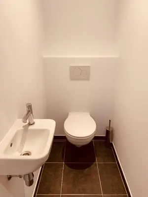 a bathroom with a white toilet and a sink at The Diplomatic Apartment in Brussels
