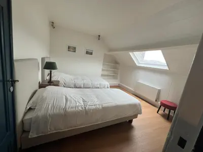 a bedroom with a large bed and a window at Denderhuis in Dendermonde