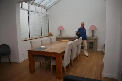 a man standing in a dining room with a table and chairs at Denderhuis in Dendermonde