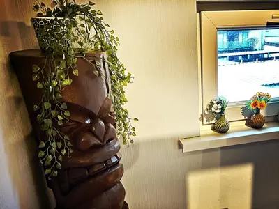 a statue of a hand holding a plant in a window at De Zweverik in Dessel