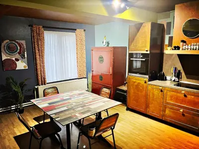 a kitchen with a table and a table and chairs at De Zweverik in Dessel