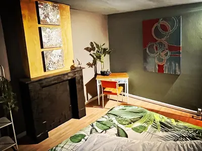 a living room with a bed and a fireplace at De Zweverik in Dessel