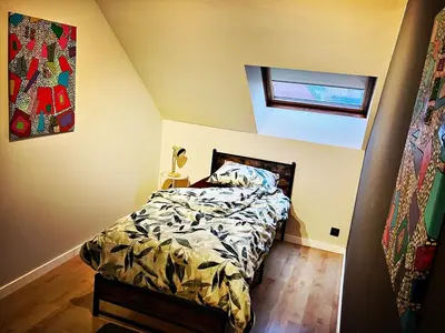 a bedroom with a bed with a comforter and a window at De Zweverik in Dessel