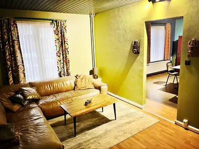 a living room with a leather couch and a coffee table at De Zweverik in Dessel