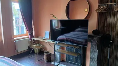 a room with a mirror and a desk with a tv at Boutique Cogels Osy in Antwerp