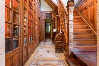 a hallway with wooden walls and a staircase with a rug at Boutique Cogels Osy in Antwerp