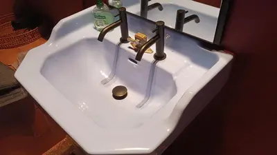 a white sink with two faucets in a bathroom at Boutique Cogels Osy in Antwerp