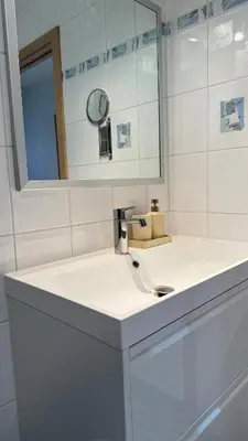 a white bathroom with a sink and a mirror at A joyful place in Ghent