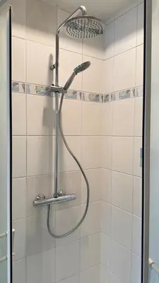 a shower with a shower head in a bathroom at A joyful place in Ghent