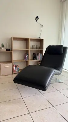 a black couch sitting on the floor in a room at A joyful place in Ghent