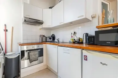 a kitchen with white cabinets and a counter top at Brussels Royal - Freedom Square in Brussels