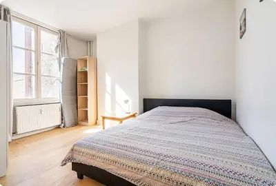 a bedroom with a bed in a white room at Brussels Royal - Freedom Square in Brussels